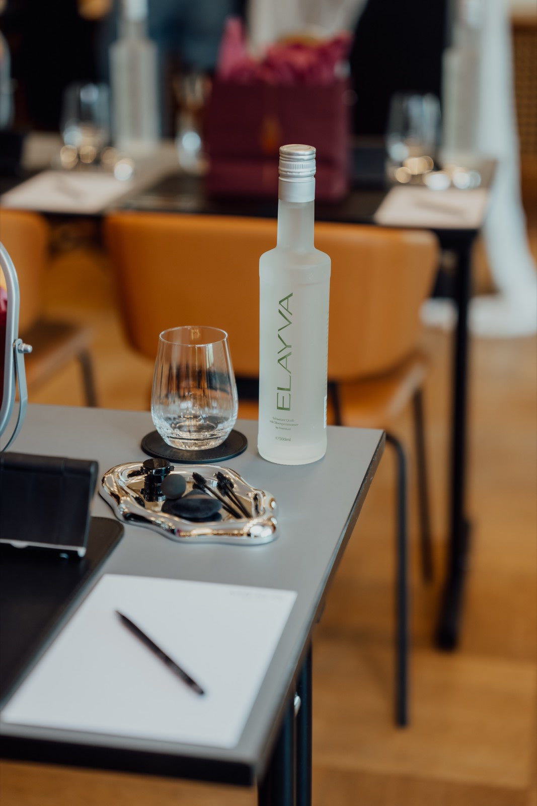 ELAYVA bottle beside a glass of water