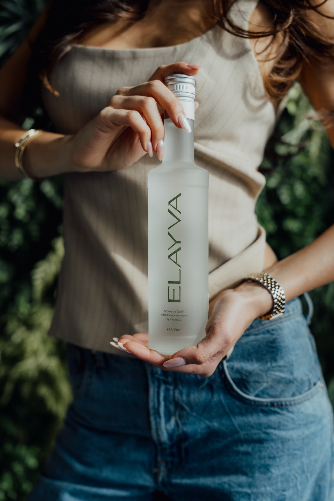 Close-up of a hand holding an ELAYVA bottle